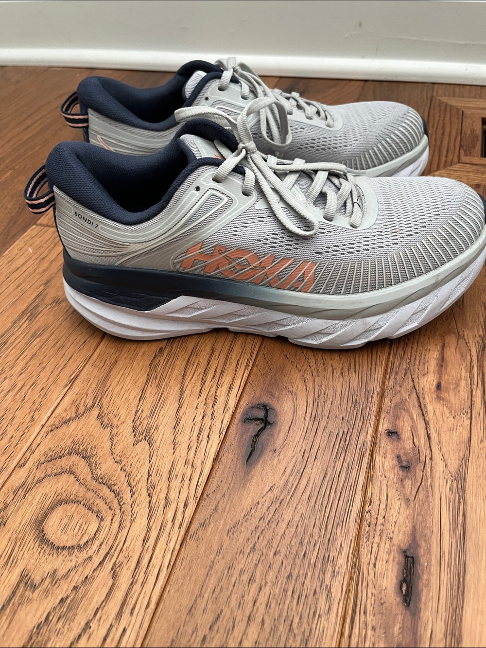 Hoka Bondi 7 woman’s Running Shoes in Light Gray with Navy and Orange Accents
